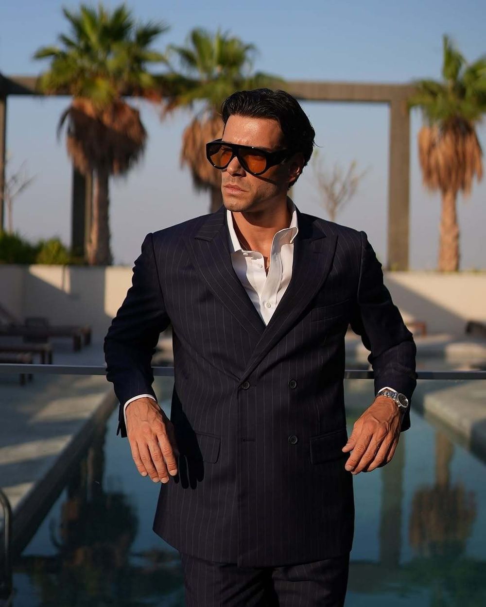 Pinstriped navy double-breasted suit with open-collar white shirt