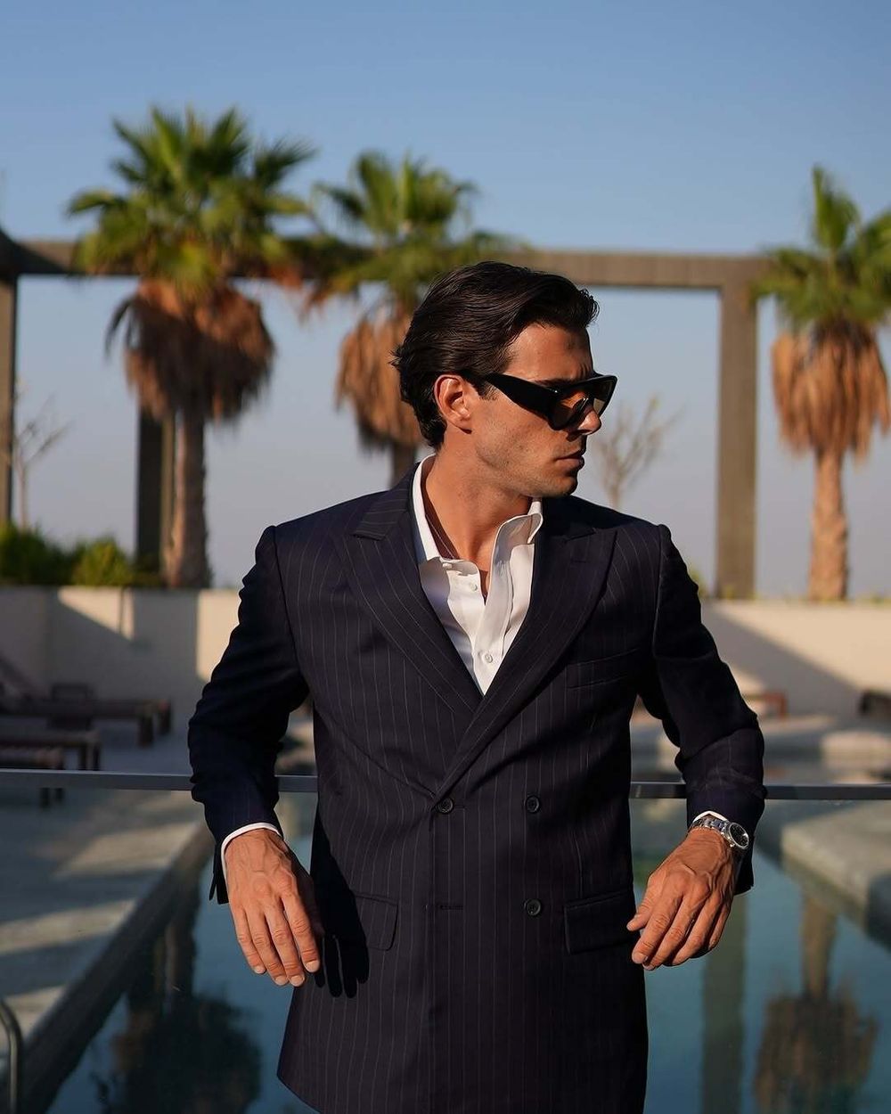 Pinstriped navy double-breasted suit with open-collar white shirt