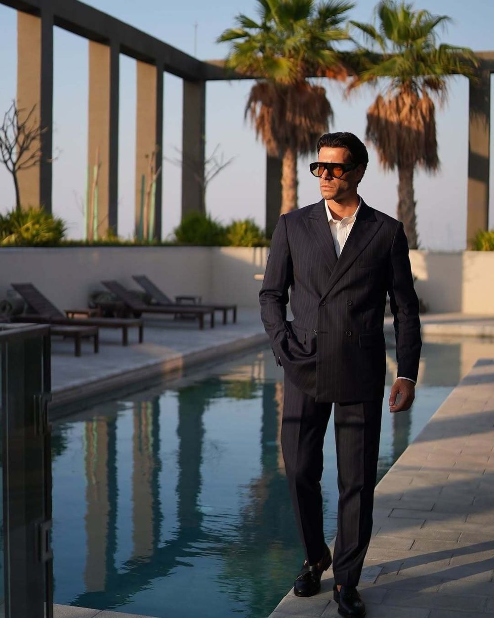Pinstriped navy double-breasted suit with open-collar white shirt