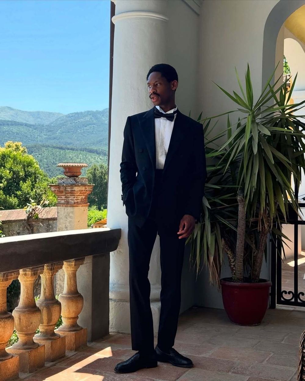 Black Satin-Lapel Tuxedo with Pleated White Shirt and Bow Tie